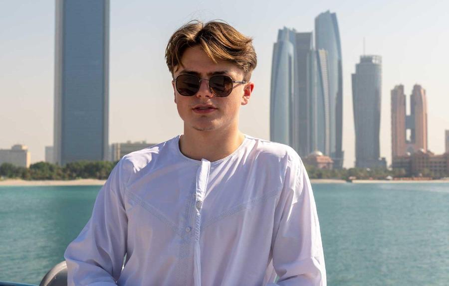 A student standing in front of the Dubai skyline