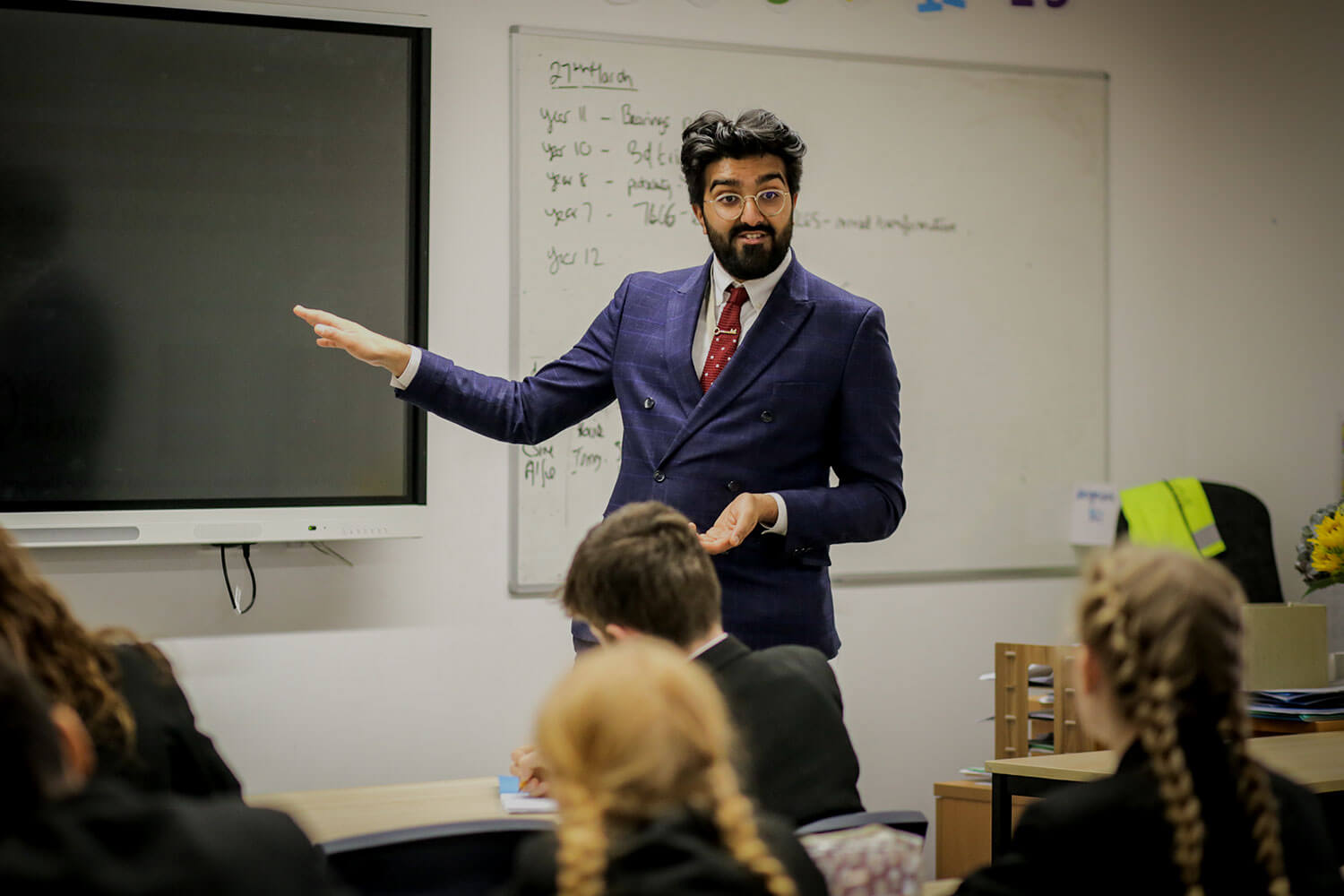 Trainee teacher addressing a classroom of pupils