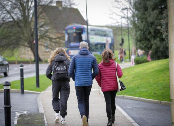 A photo showing the back of a family walking at Newton Park campus