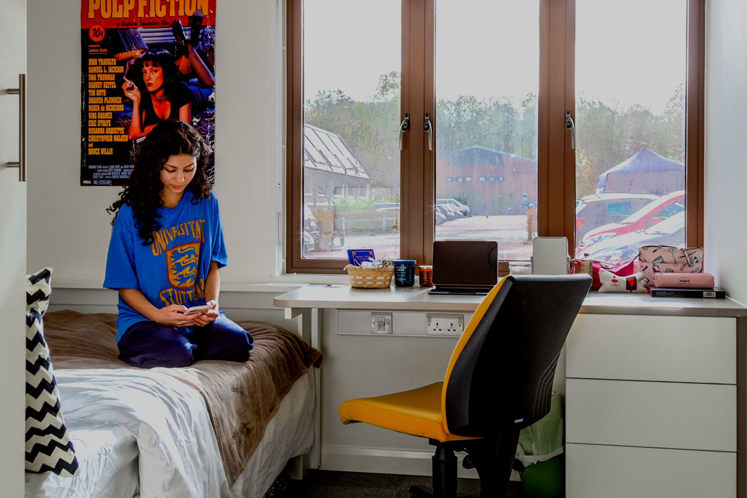 Student sat on bed in accommodation student halls