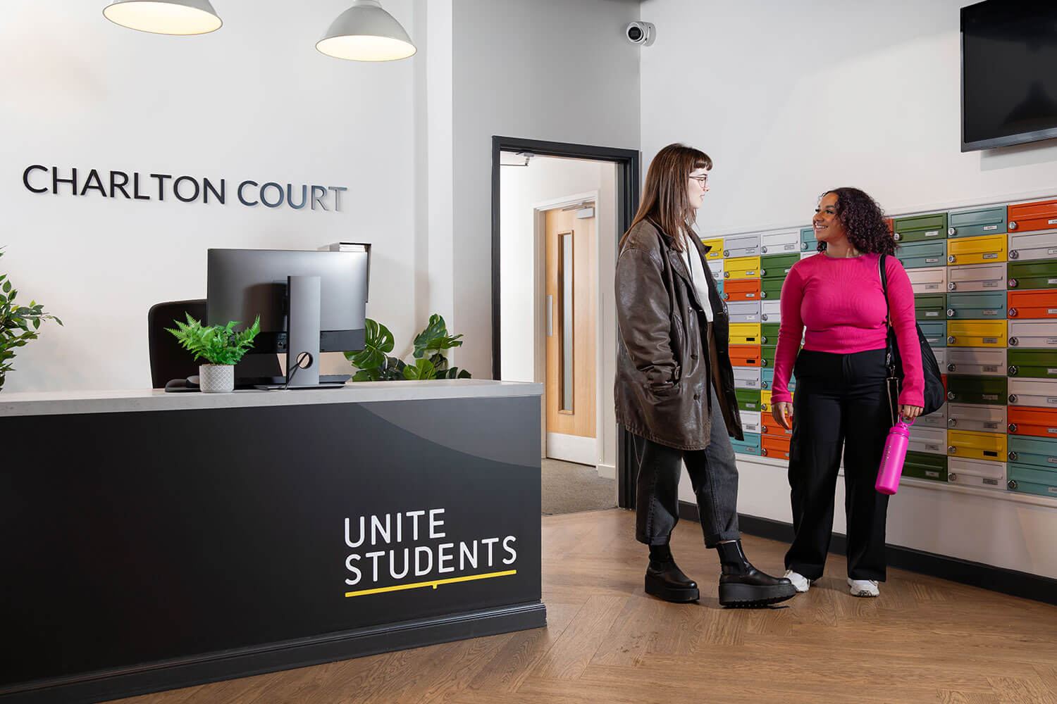 Two students chatting in a modern reception space