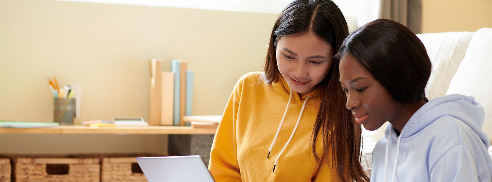 Two students in their accommodation looking at a laptop screen