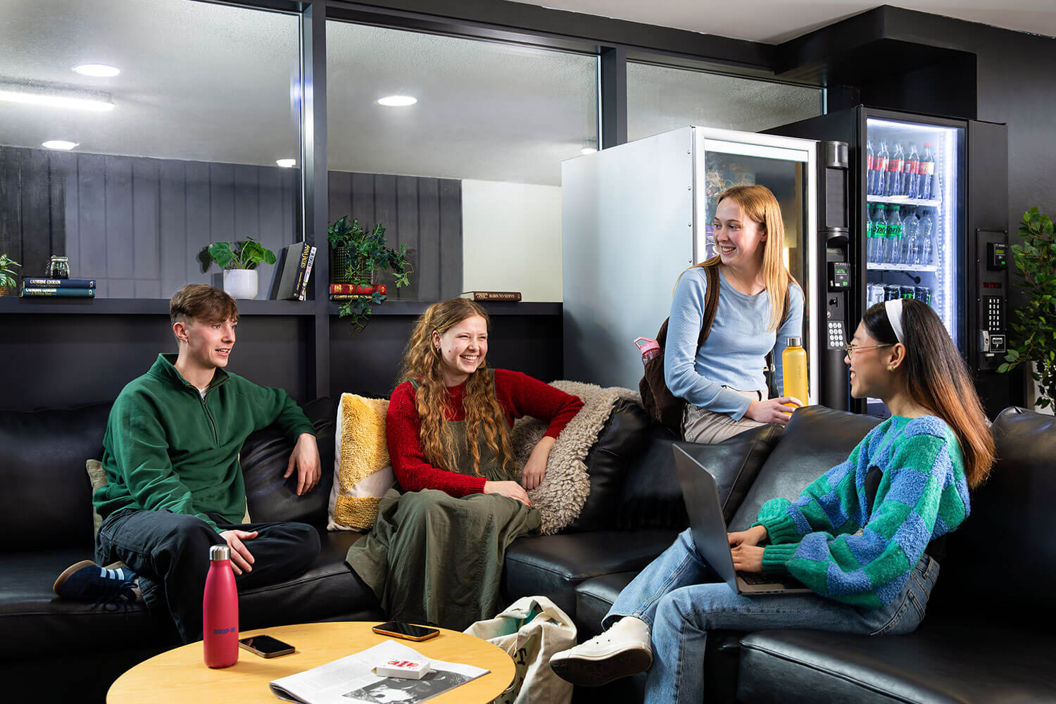 Four students sitting on sofas in the common area at Waterside court