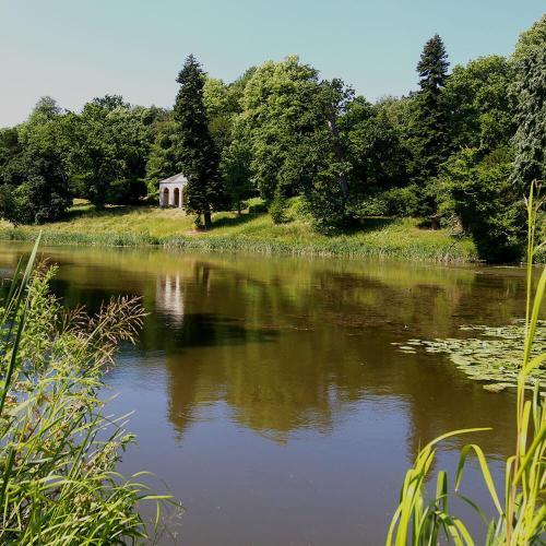 The lake at Newton Park on a sunny day with a view of the temple