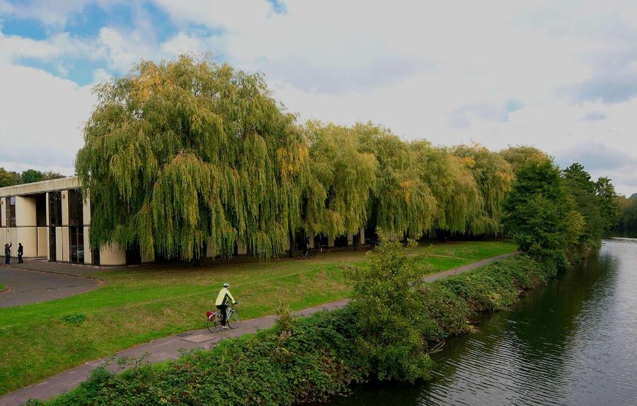 View of the Locksbrook Road building from the river, with a cyclist in the foreground