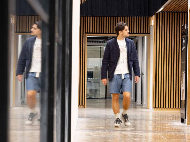 Visitor walking past reflective glass structures within our Locksbrook building