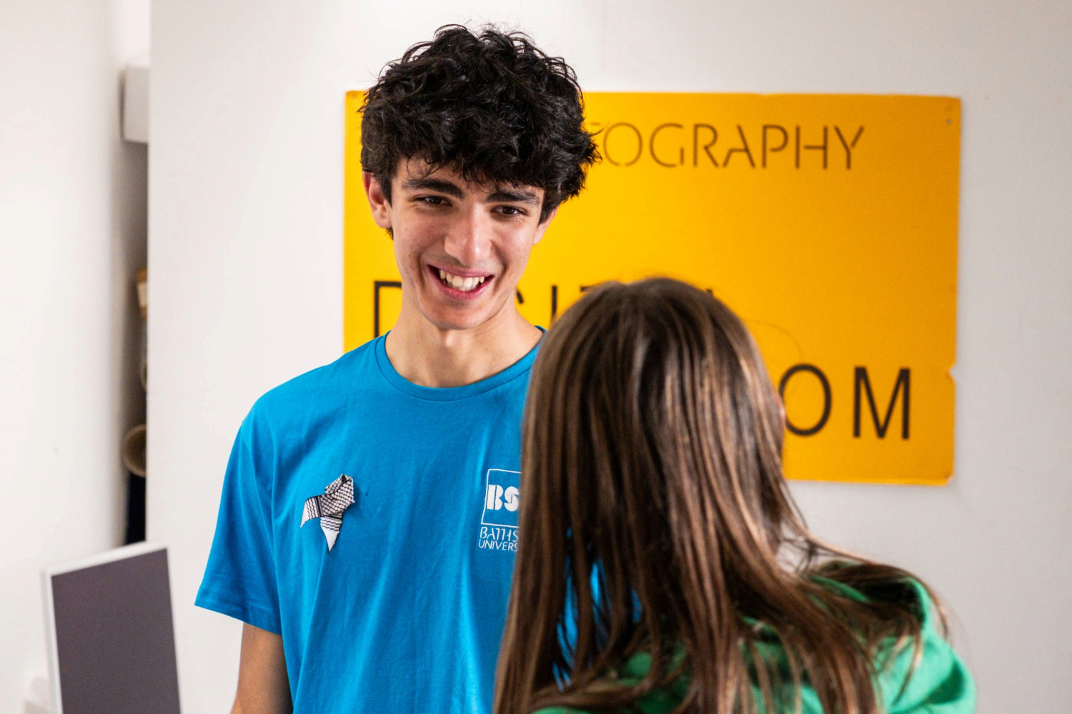 Young male student with black curly hair in the photography department