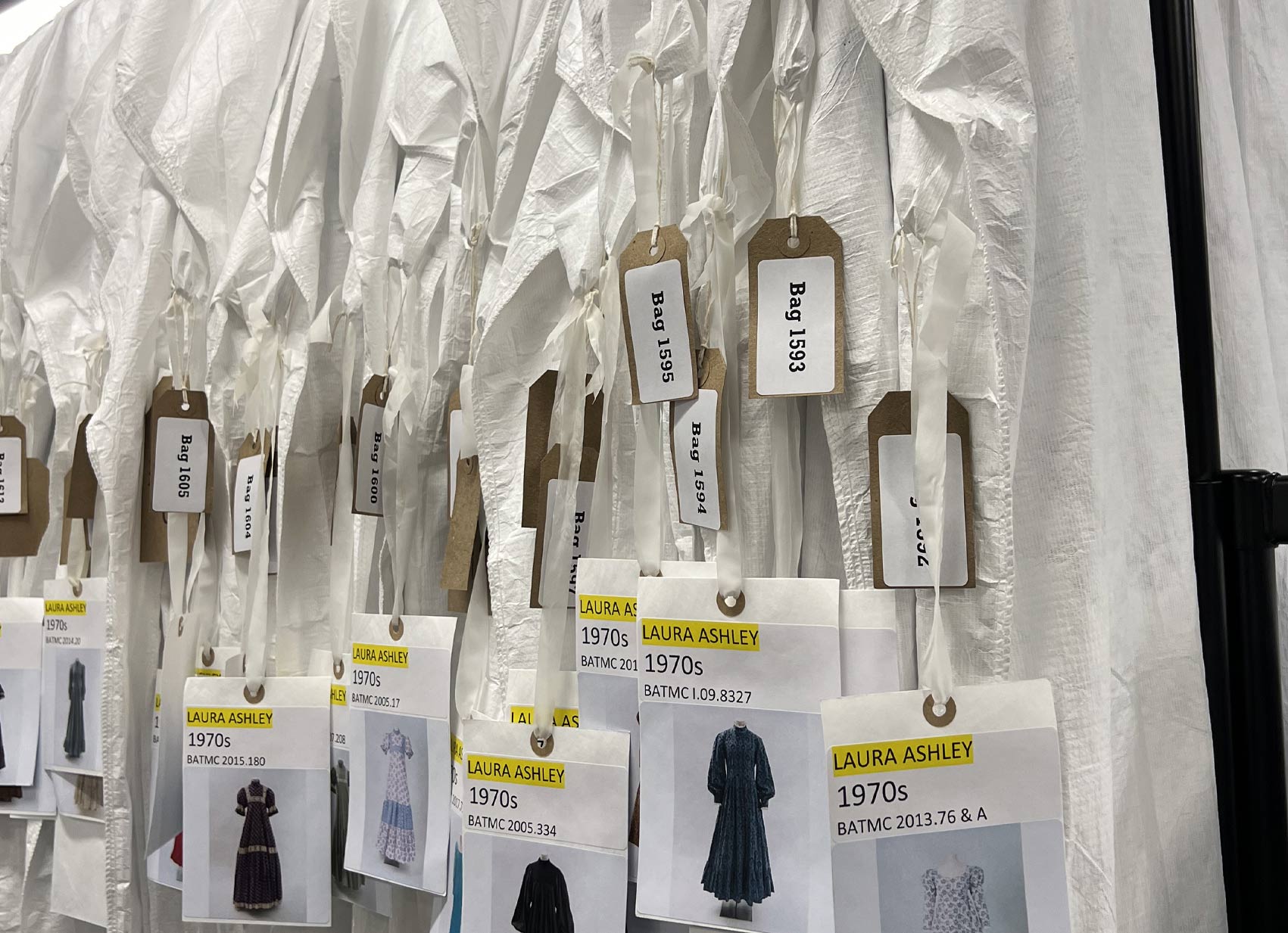 RAIL OF DRESSES IN BAGS WITH LABELS