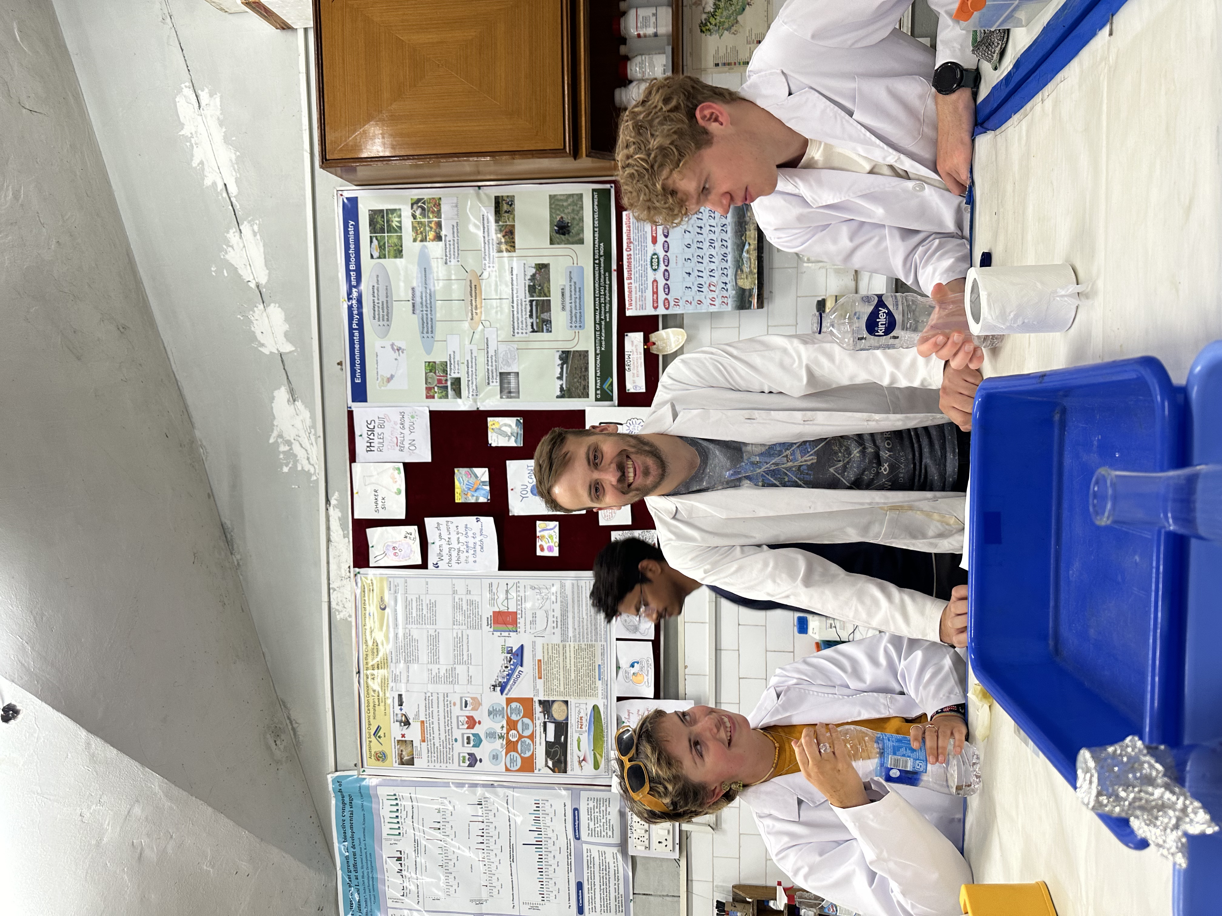 Three young people in a laboratory wearing white coats