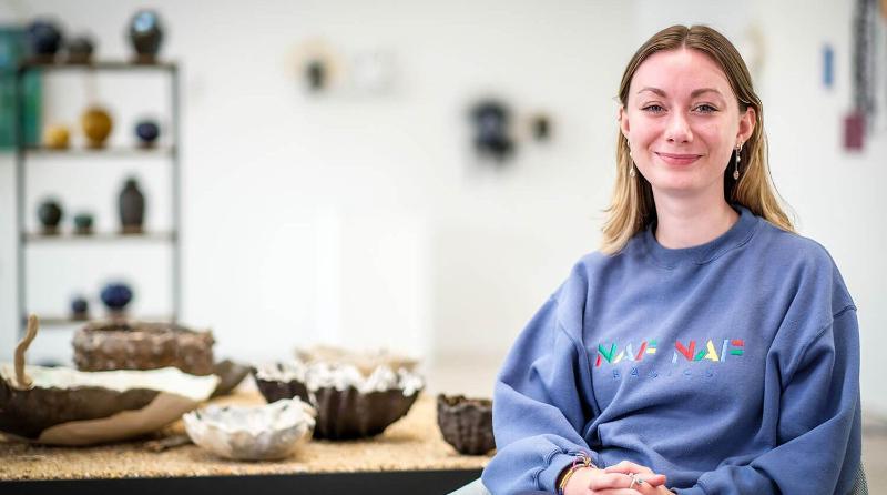 Smiling woman sitting in a ceramics studio