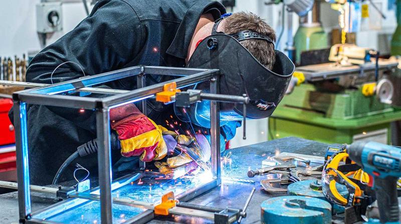 Student welding in a metalworking workshop