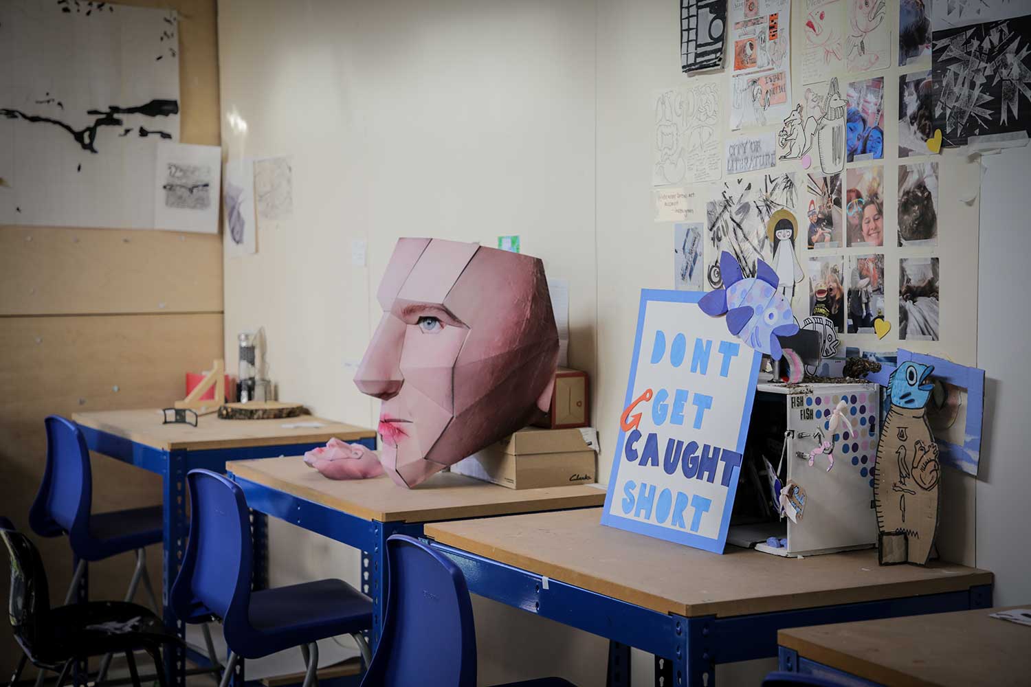 Students' desks adorned with artwork and sculptures