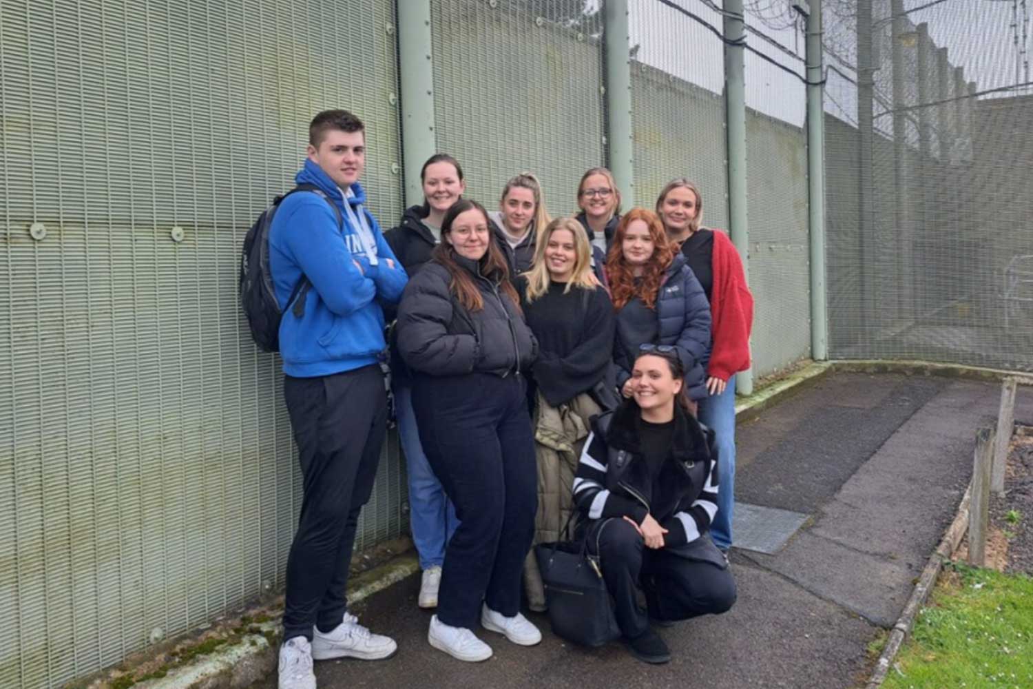 A group of nine Criminology students stand outside the boundary of HMP Erlestoke prison