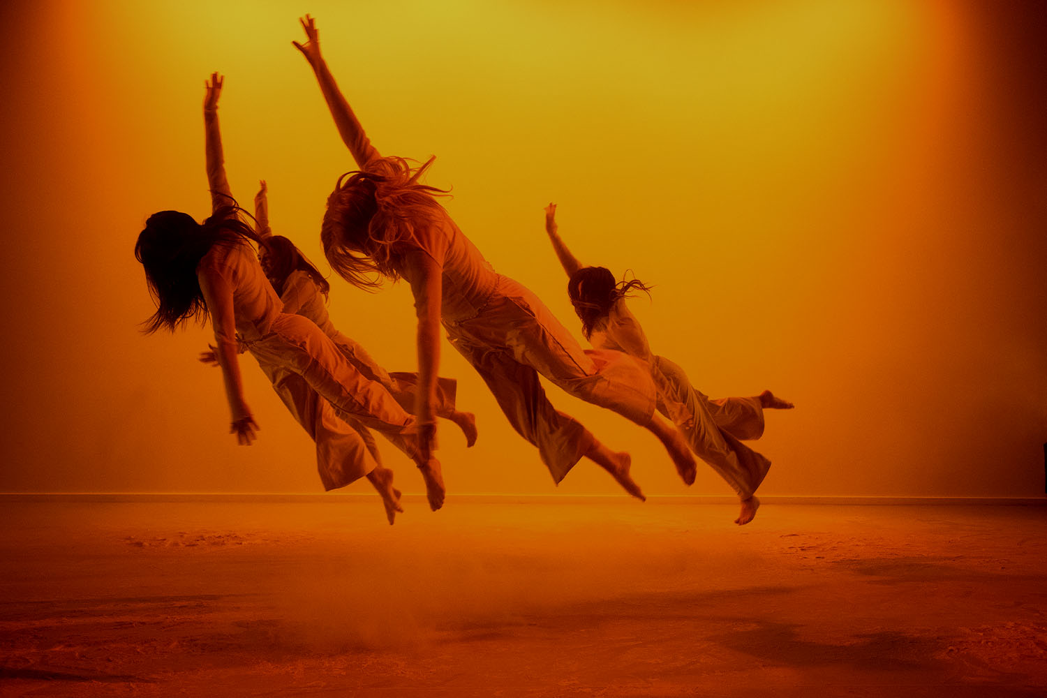 Four dancers appear to float through the air during a performance