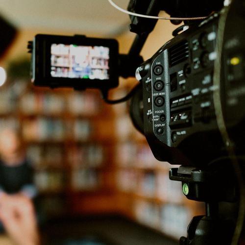 A camera focused on a subject in the background in a library