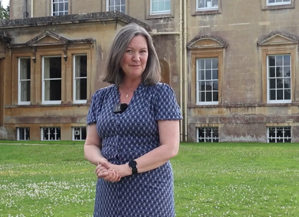 Kate stands in front of Main House