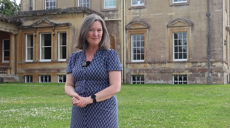 Kate stands in front of Main House