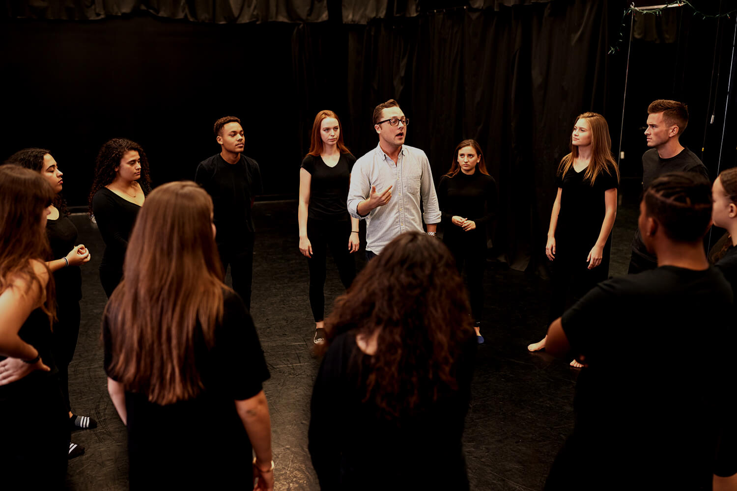 Teacher with drama students in studio.