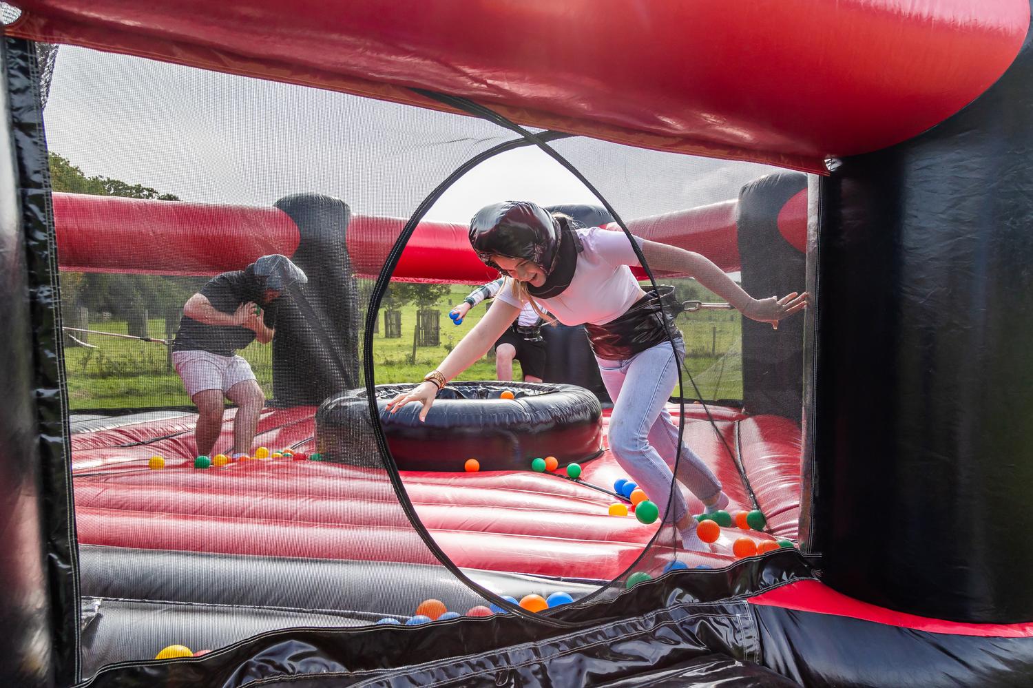 Students playing on a red and black inflatable obstacle course