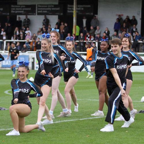 A group of cheerleaders on a football pitch