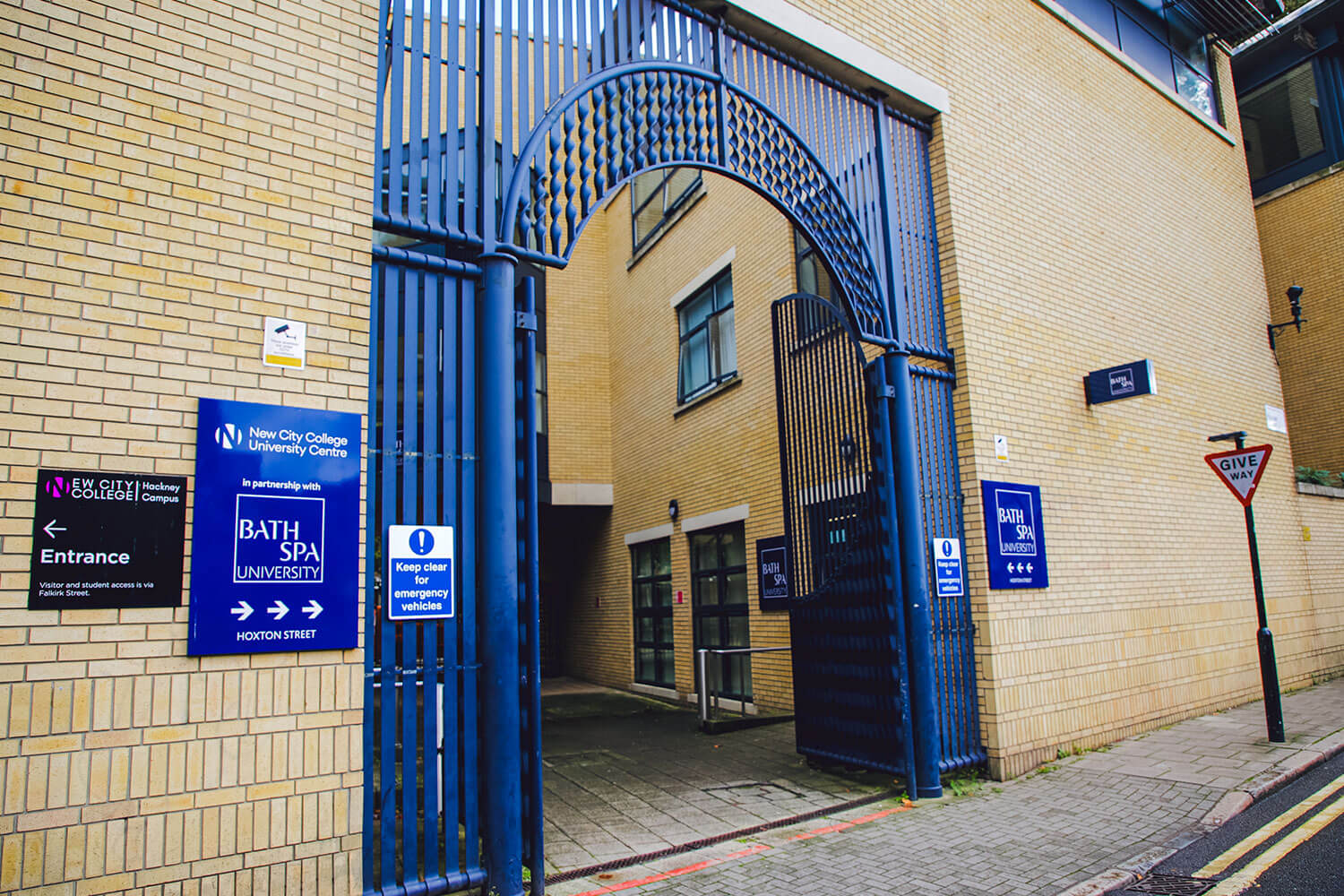 A blue front gate with blue Bath Spa University signs