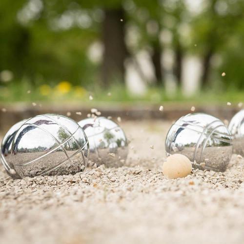 Four silver boules next to a jack on a boules pitch