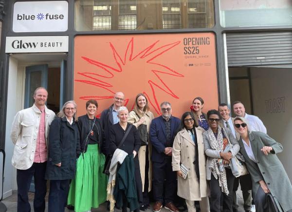 A group of people gather in front of soon to open Somer Store in Bath