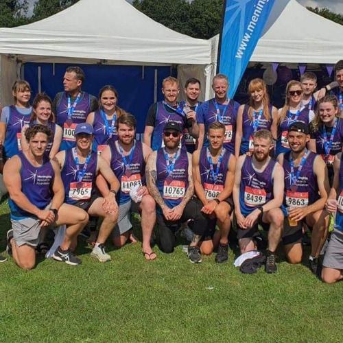 A group of runners huddle together for a photo