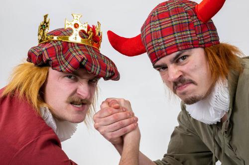 Two people dressed in tartan hats pretending to arm wrestle