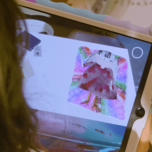 A child looking at a hand-drawn card through an Ipad