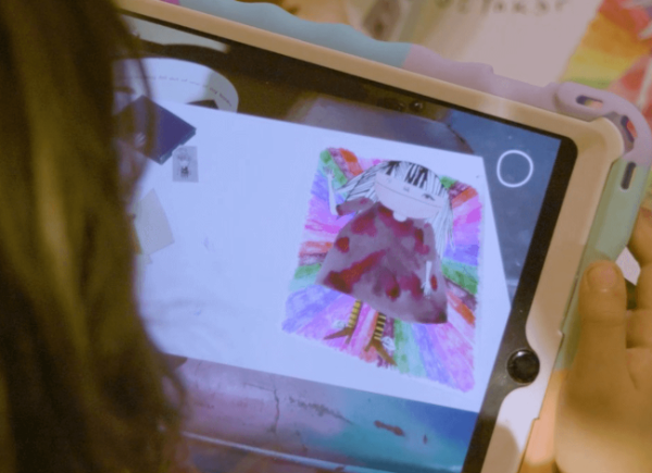 A child looking at a hand-drawn card through an Ipad