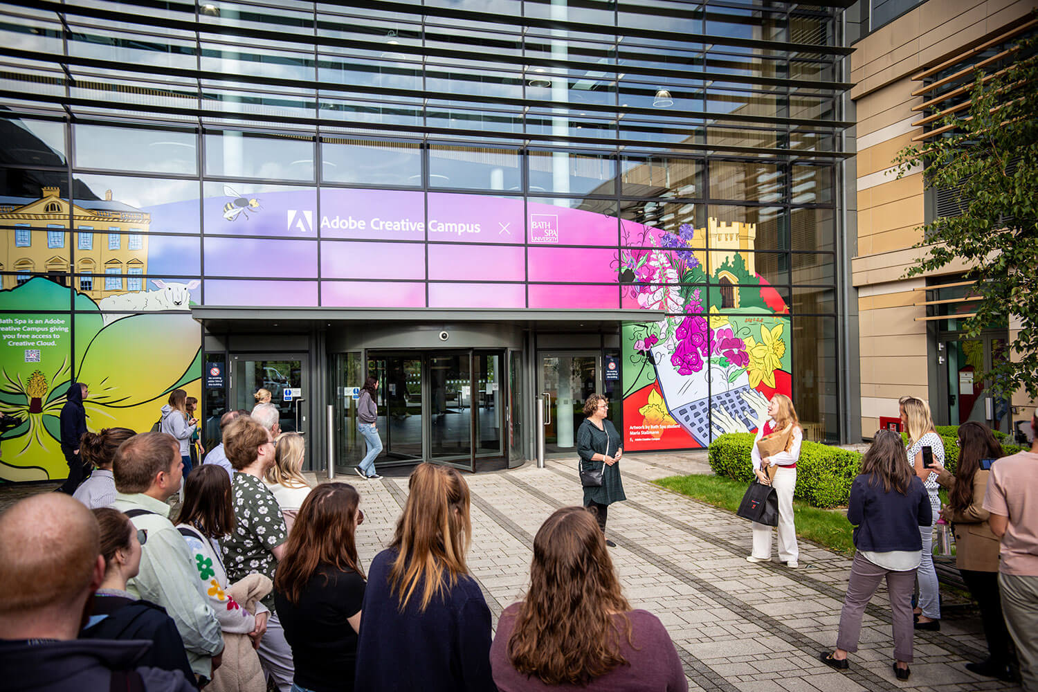 People gather around the unveiling of a colourful mural