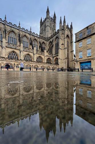 Bath Abbey with its reflection in a pool of rainwater below it