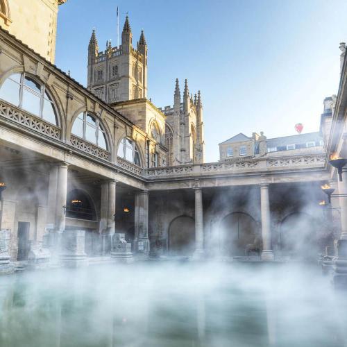 Mist rising off the Roman Baths with the iconic Bath Abbey in the background