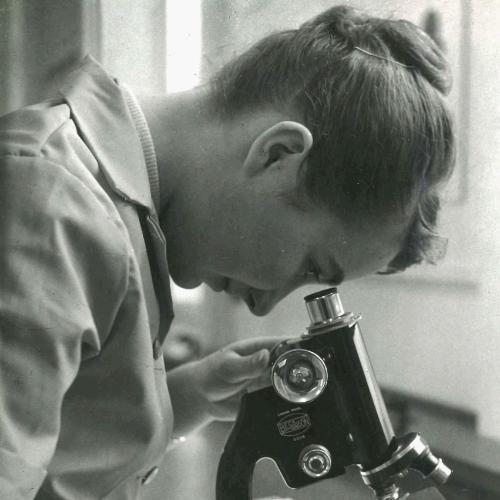 A woman looking through a microscope