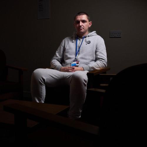 Man sitting on a chair under a spotlight