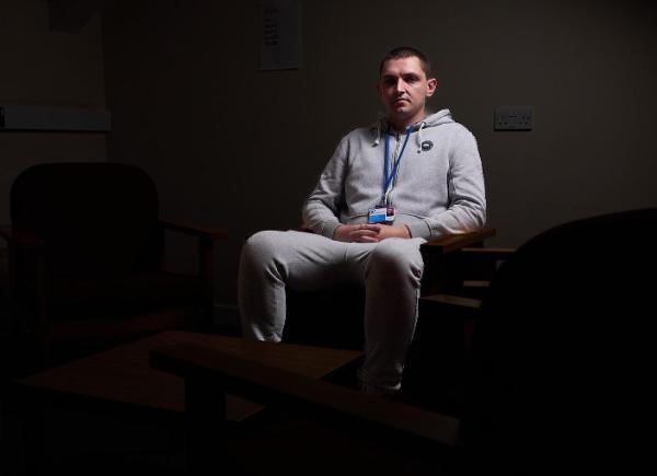 Man sitting on a chair under a spotlight