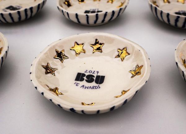 A decorated ceramic bowl, featuring gold stars and the BSU logo, for 2024 VC awards. 
