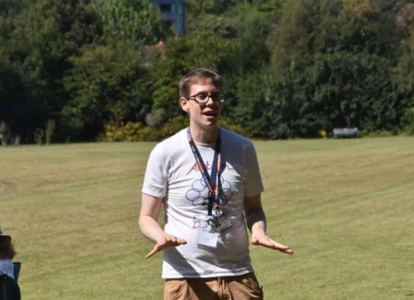 a man in a white t-shirt in a green field