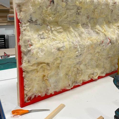 A panel covered with wool sitting on a workbench