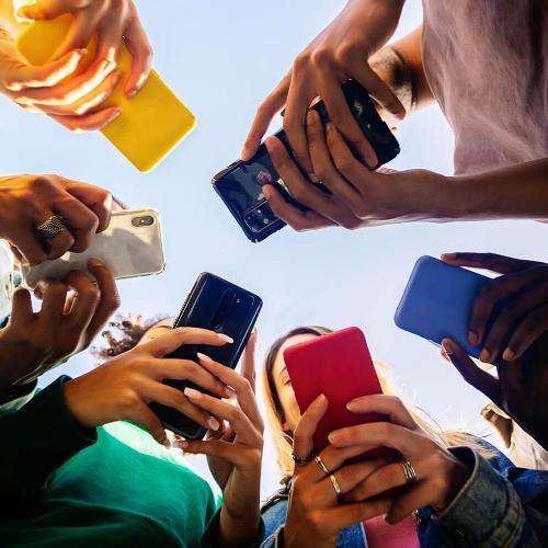 A number of people holding mobile phones in a circle