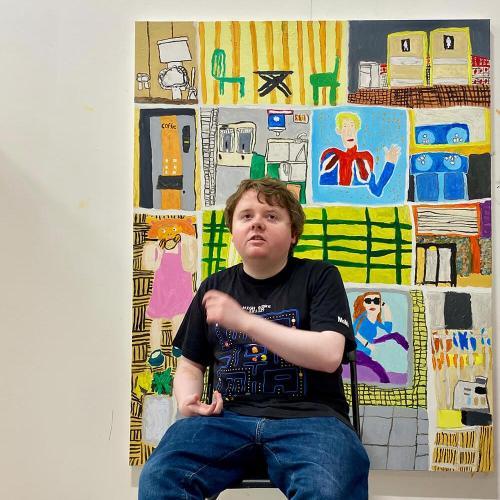 Benedict Robinson poses in front of one of his paintings