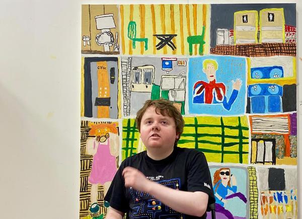 Benedict Robinson poses in front of one of his paintings