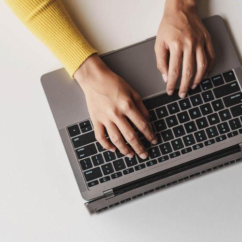 hands typing on laptop keyboard