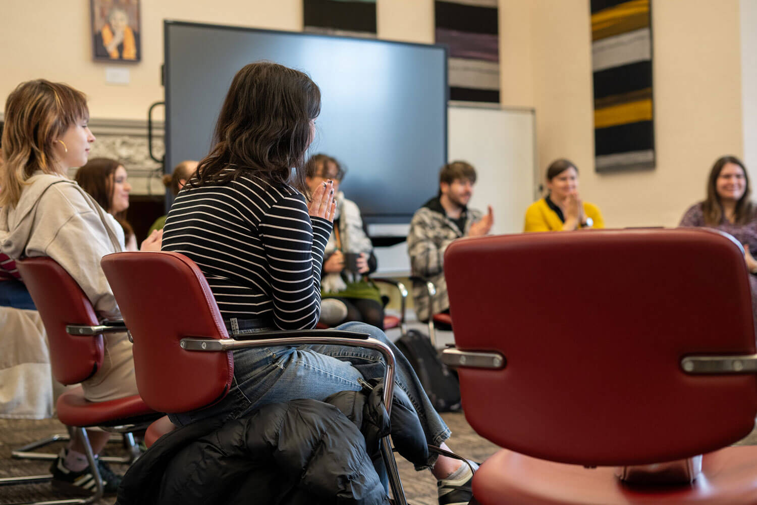 A group students sat in a circle applauding