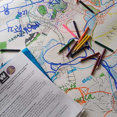 Overhead photo of colouring pencils and paper on a desk