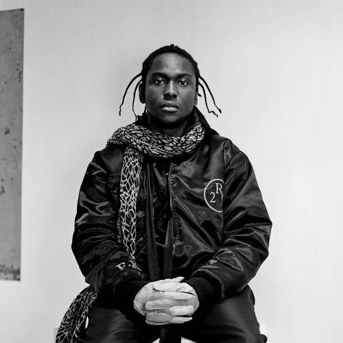 A black and white portrait of a person sitting on a plinth in an art gallery