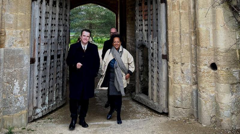 A man and a woman stand in a doorway in the grounds of Newton Park