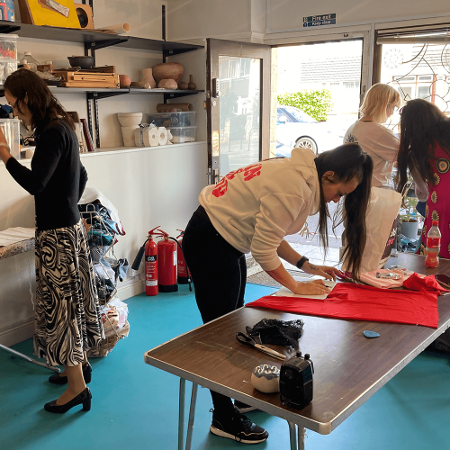 A group of people mending clothes and making projects together.