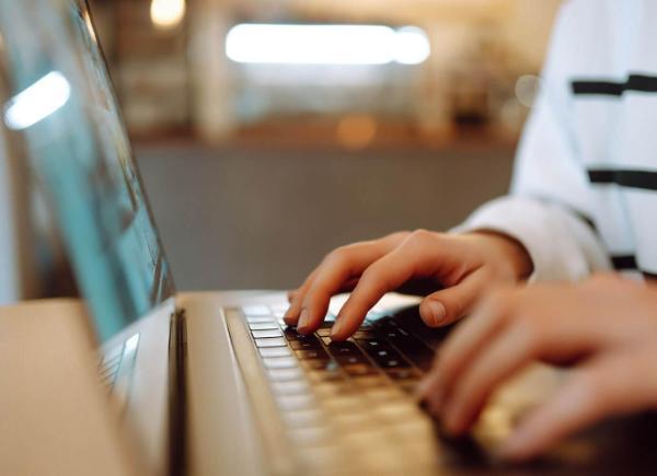 hands typing on laptop keyboard